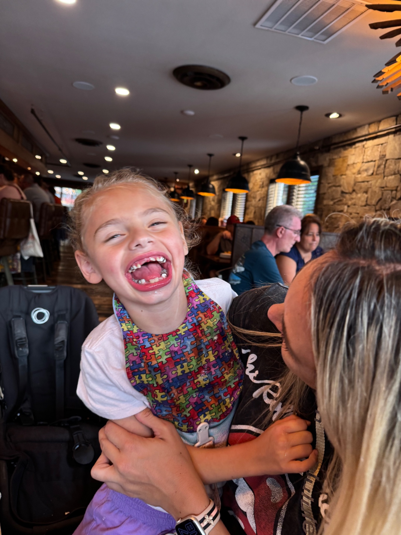 Ava laughing with her whole face while being held