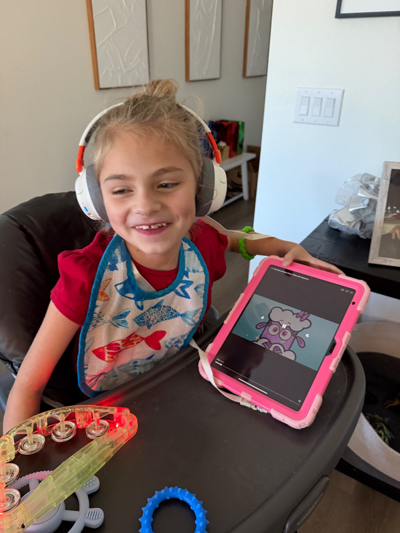 Ava wearing headphones and enjoying a video on her tablet