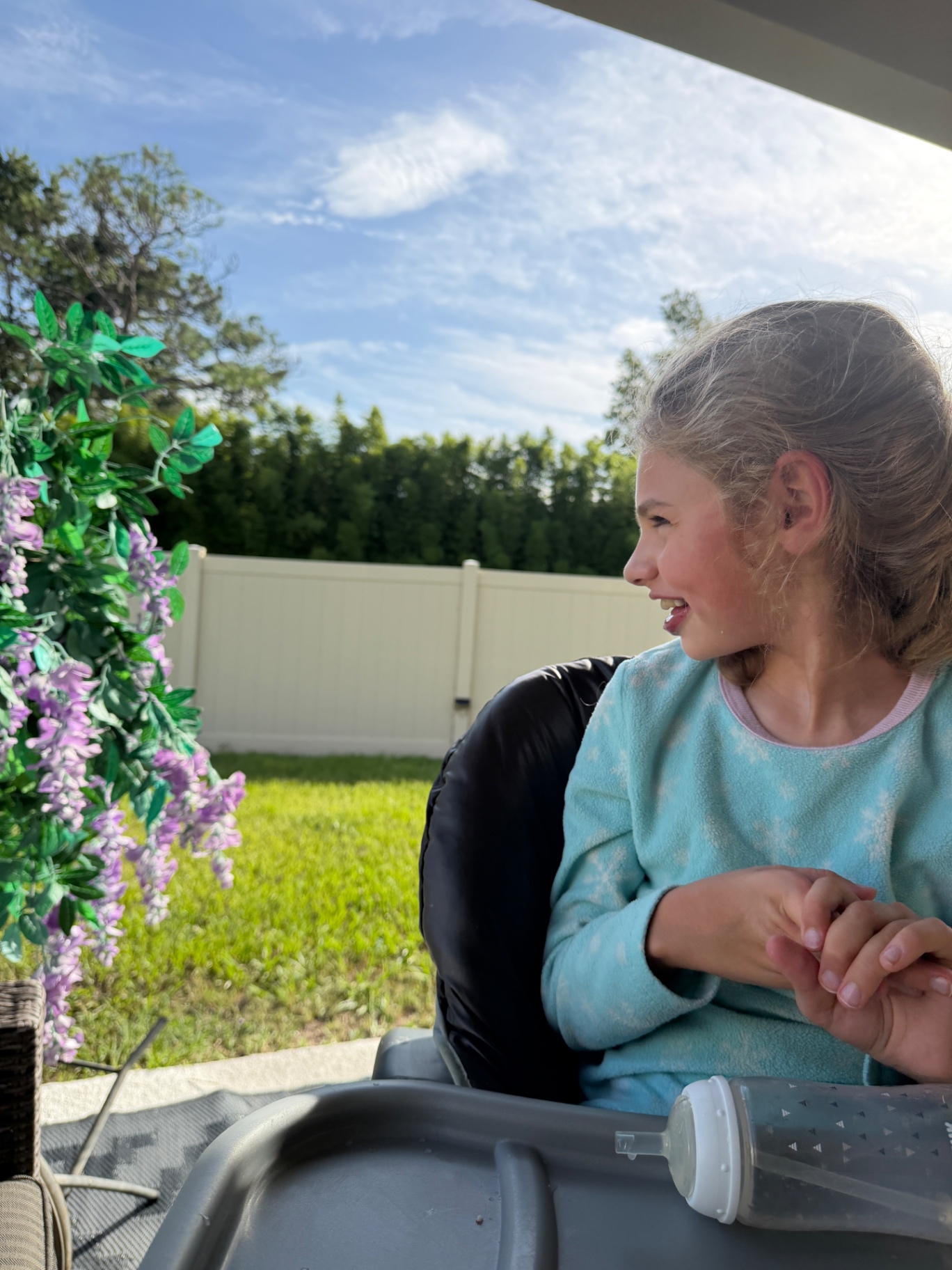 Ava smiling in the afternoon sun in the backyard