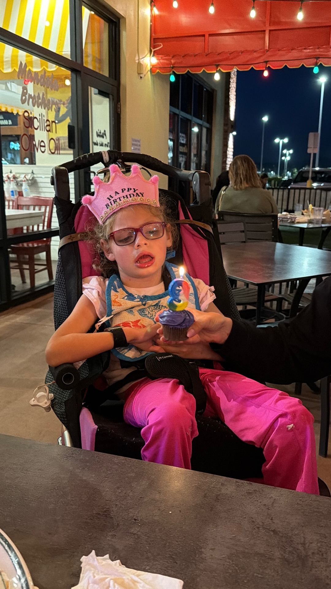 Ava in a birthday crown with a cupcake and candle