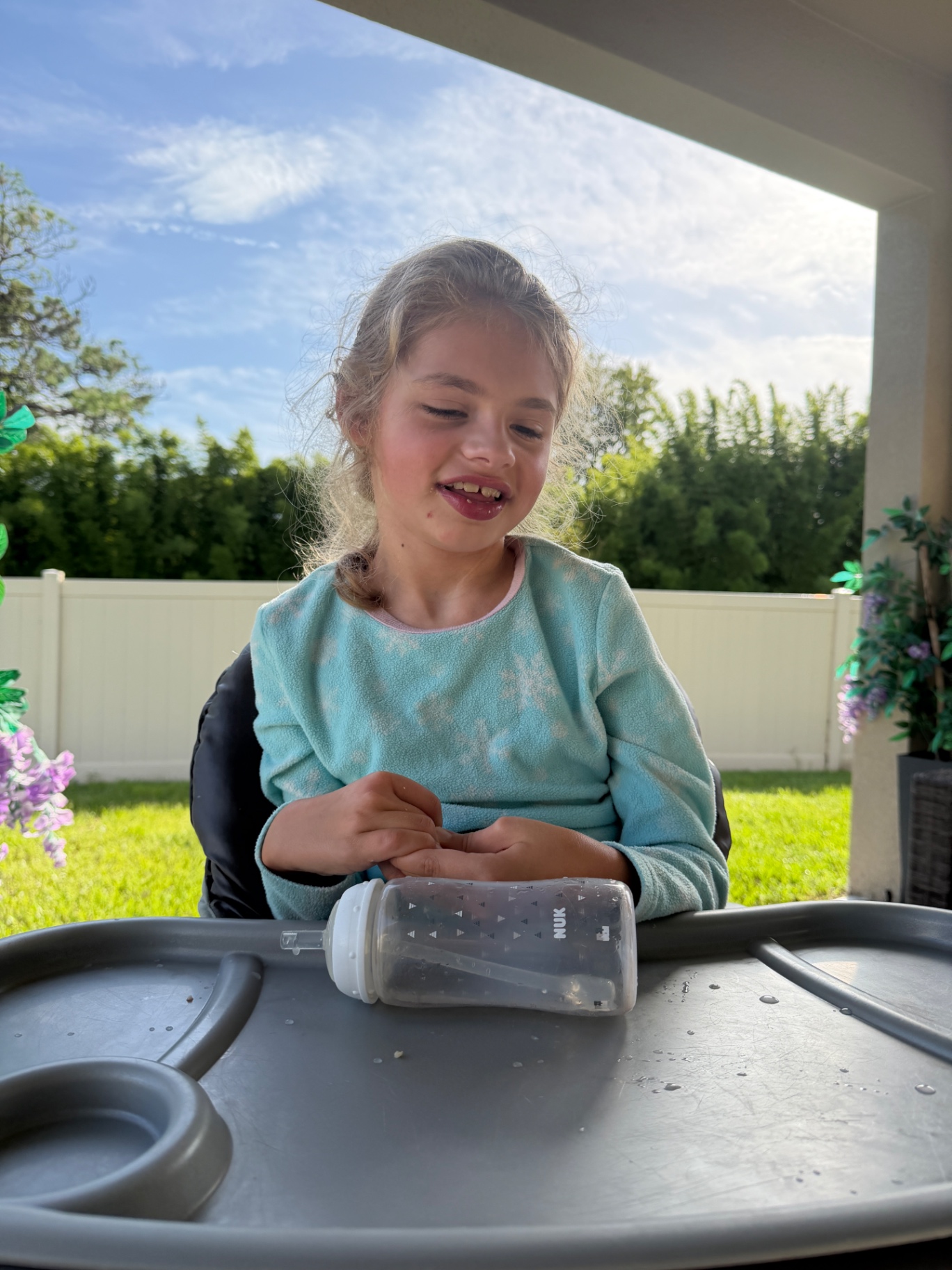 Ava laughing at her tray table outside